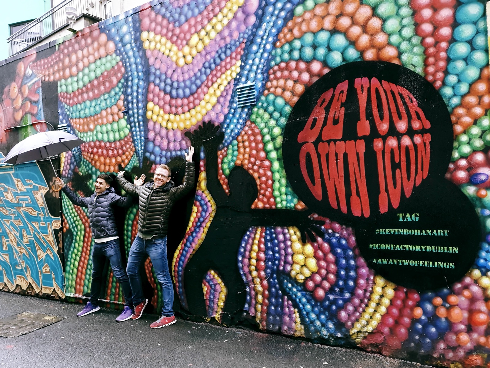 Arthur and Jeremiah posing against The Icon Walk mural