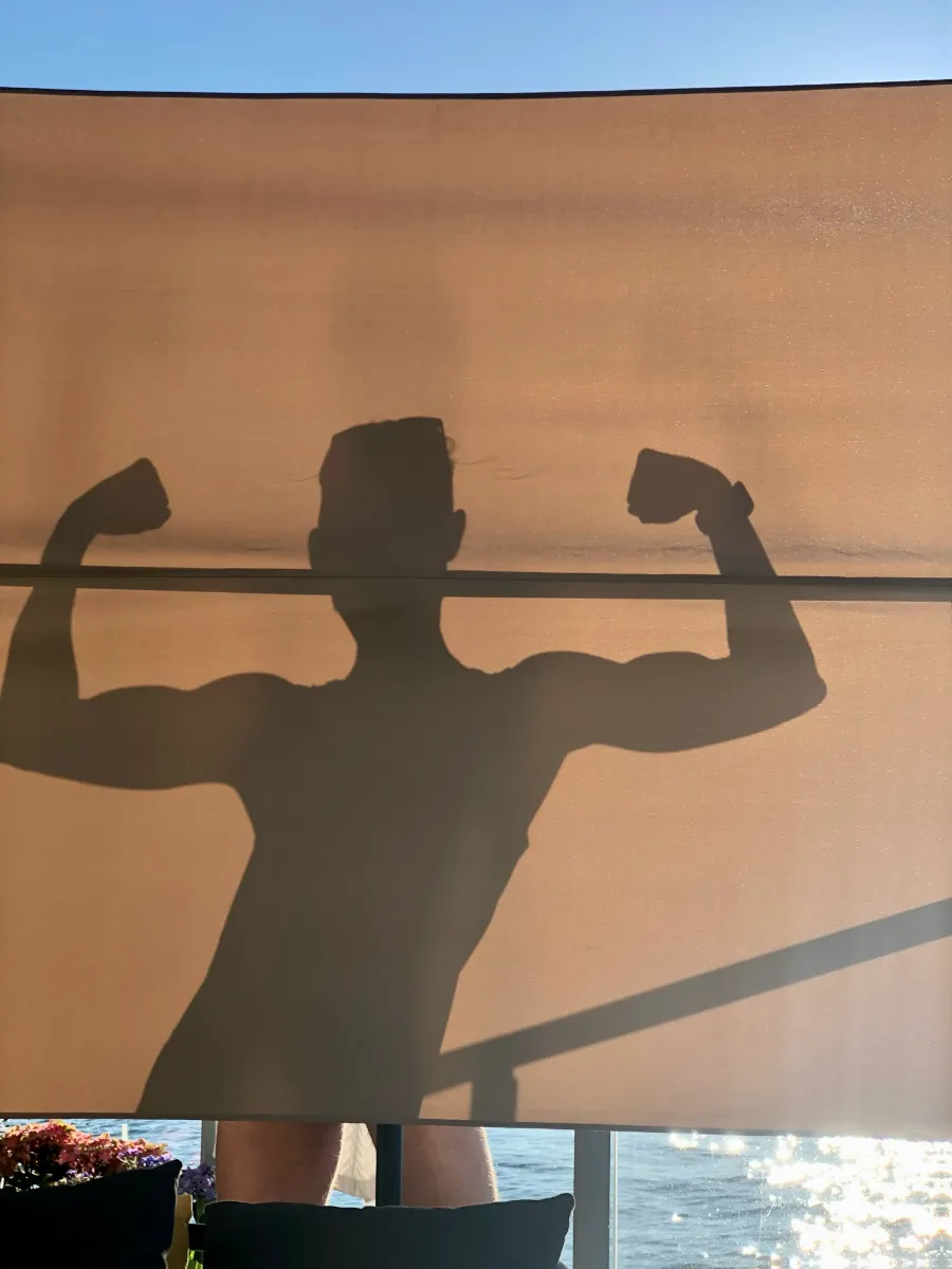 Silhouette of Jeremiah flexing double biceps on sun shade