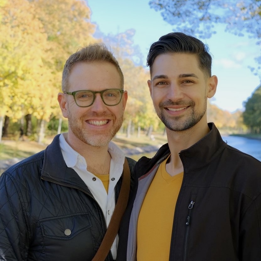 Arthur and Jeremiah smiling in front of trees turning colors in the fall