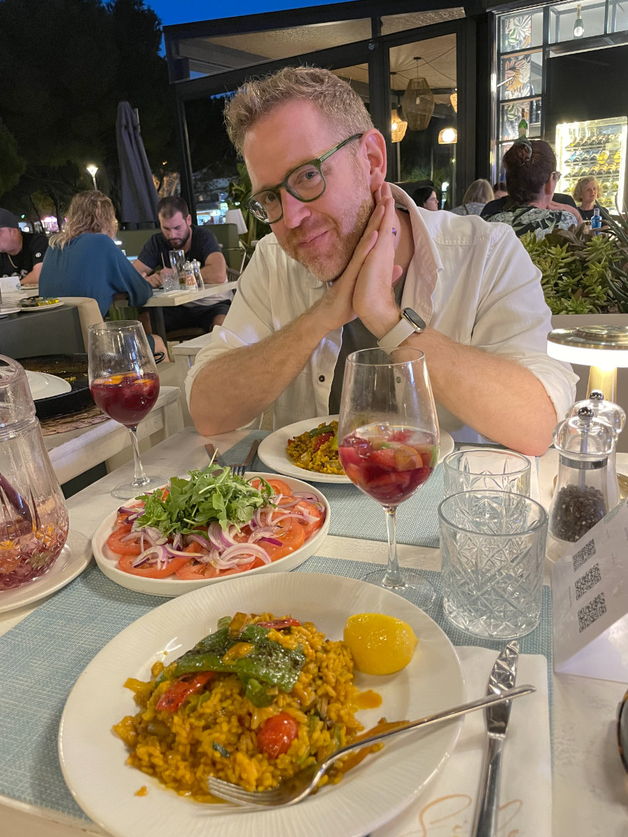 Arthur smiling over a dinner of paella