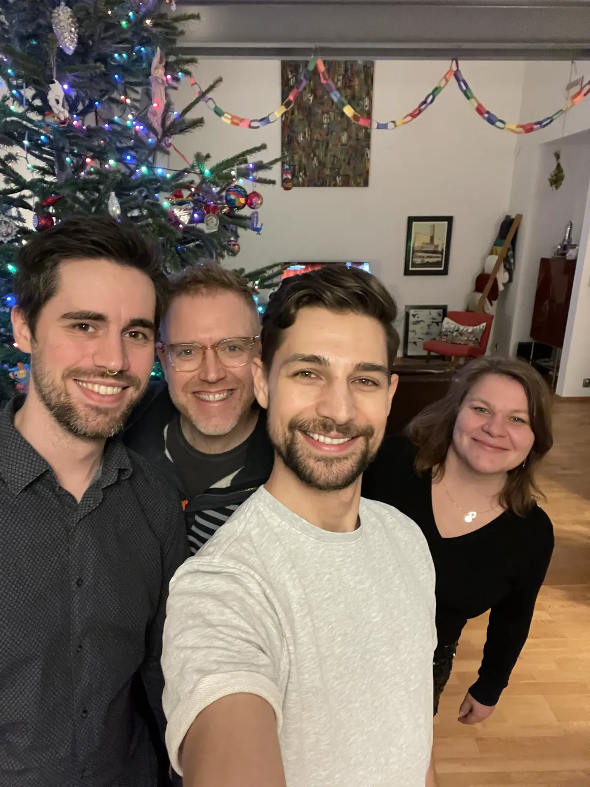 Malte, Arthur, Jeremiah, and Karin smiling in front of Christmas tree