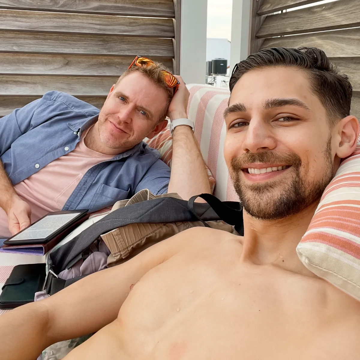 Arthur and Jeremiah laying on a beach sofa smiling