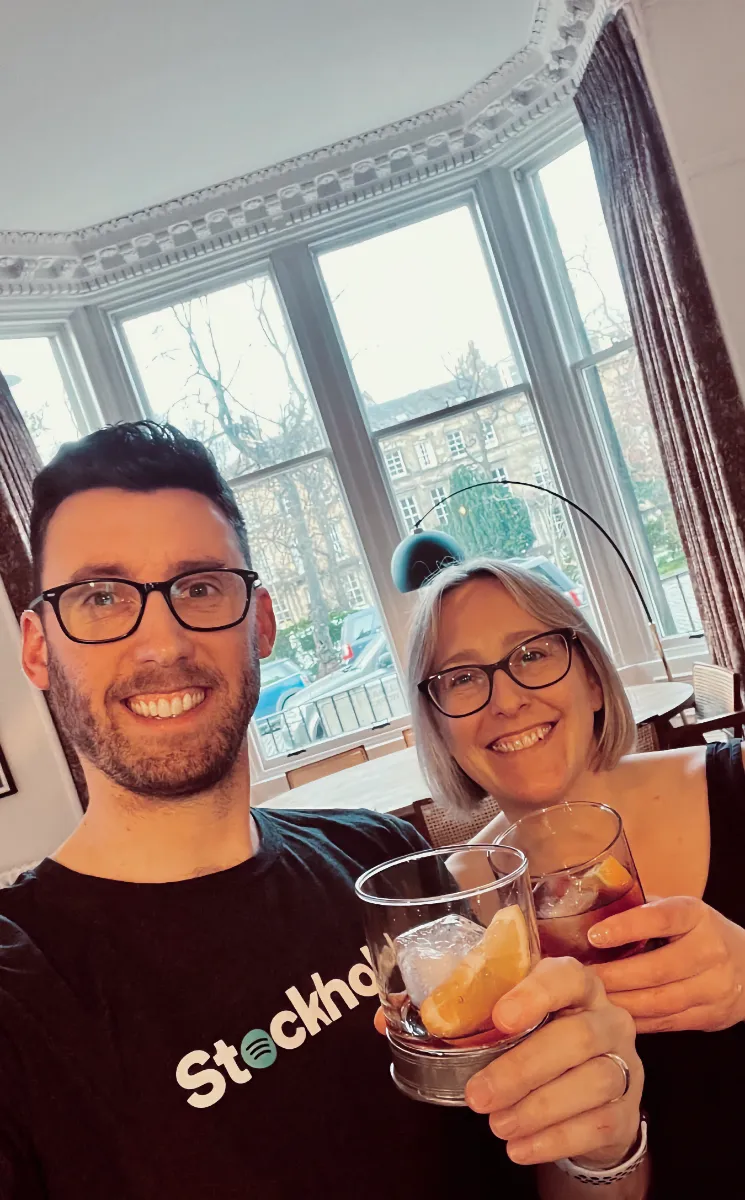 Chris and Terry holding a cocktail in their home