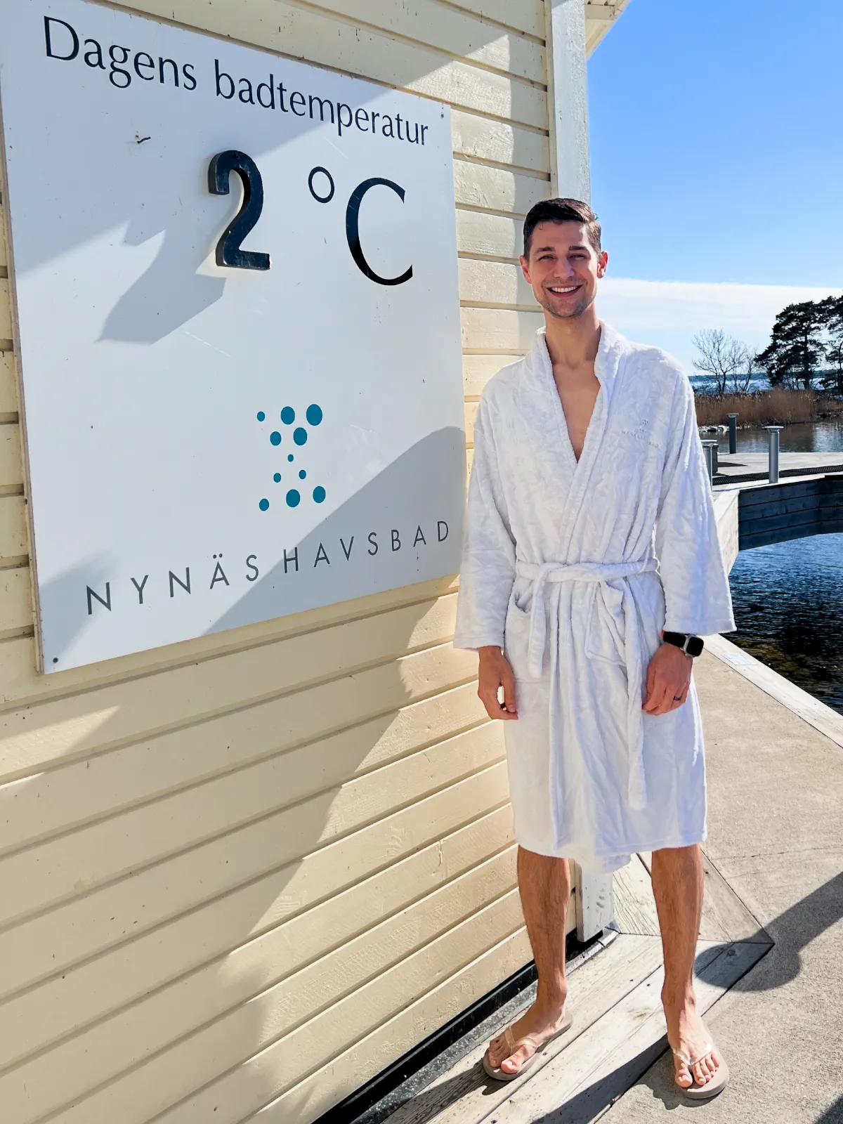 Jeremiah standing in front of a sign with the current water temperature of 2 degrees