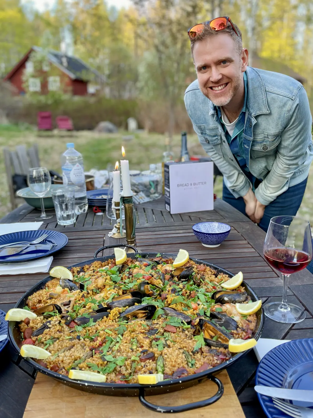 Arthur standing over a table with a big paella in the foreground