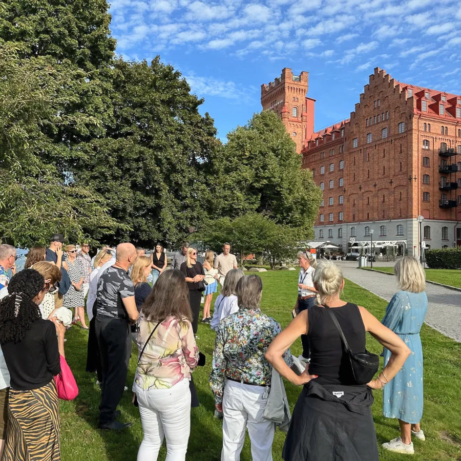 Tour guide speaking to group in front of Elite Hotel