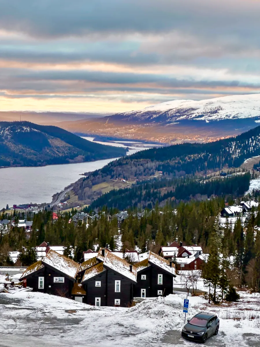 Snow covered mountains with sun shining on lake behind snow covered houses