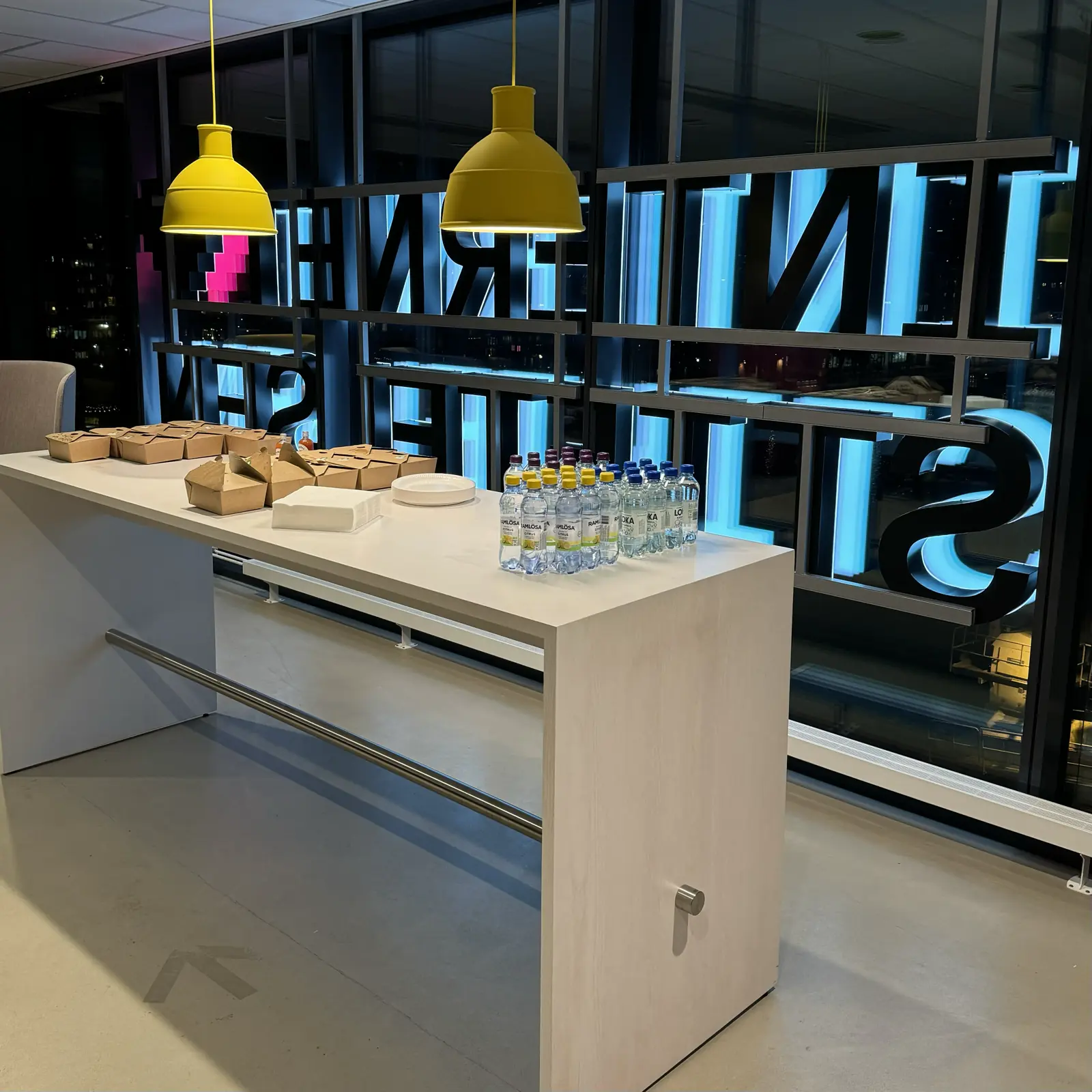 Table with food and drinks set. Internetstiftelsen sign illuminated on the outside window