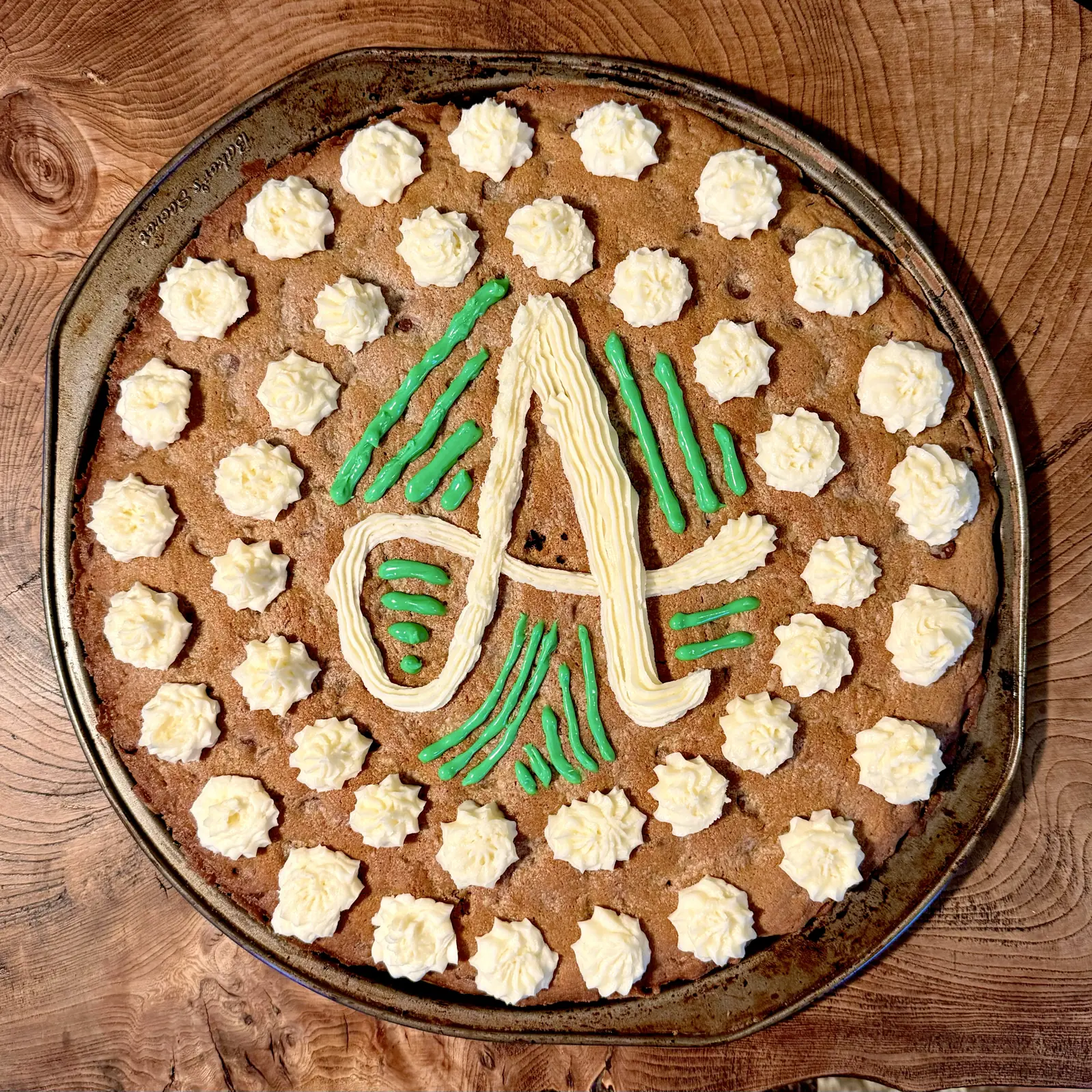 cookie cake with decorative A in frosting with 40 white frosting dots