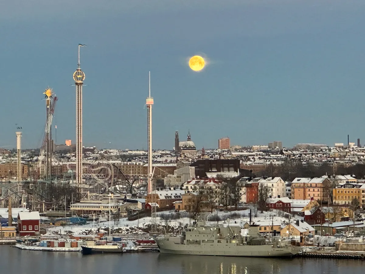 Gröna Lund at night covered in snow with full moon in sky